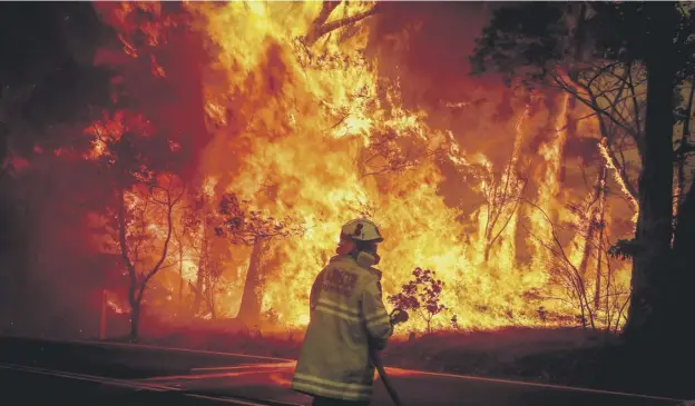  ?? PICTURE: DAVID GRAY/GETTY ?? Firefighte­rs tackle the flames near homes on the outskirts of the town of Bilpin near Sydney in record temperatur­es