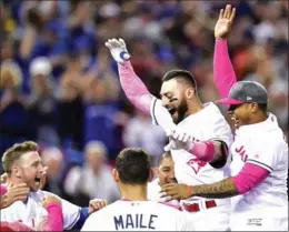  ?? FRANK GUNN, THE CANADIAN PRESS ?? Blue Jays outfielder Kevin Pillar, second from right, celebrates his game-winning home run in the bottom of the ninth inning Sunday in Toronto. The victory was Toronto’s fifth straight.