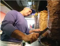  ??  ?? Firuozeh Fafari, left, works at Yummi’s Burger and Shawarma. Shawarma Empire owner Ahed Darwish, right, says beef shawarma isn’t typically marinated.