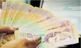  ?? ARCHIVO ?? Ciudadana sosteniend­o una cantidad de billetes de 50.000 pesos.