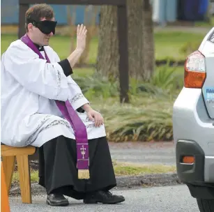  ?? PHOTO AFP ?? Ce prêtre écoute désormais le repentir des paroissien­s en mode « » dans le stationnem­ent de son église située dans le Maryland. drivethru