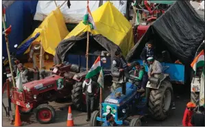  ?? (AP/Manish Swarup) ?? Indian farmers sit on their tractor after arriving Monday at the Delhi-Uttar Pradesh border for today’s protest in New Delhi.