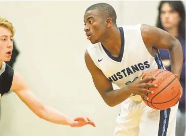  ?? Jerry Baker / For the Chronicle ?? Kingwood senior guard Cortez Williams, right, works the ball against Conroe defender Victor Bernald during the Mustangs’ 56-33 win last week.