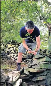  ??  ?? ■ Local sculptor, Graeme Mitcheson checking the quality of a stone on land at Botany Bay, off One Barrow Lane, Charley, in preparatio­n for the carving of the memorial.