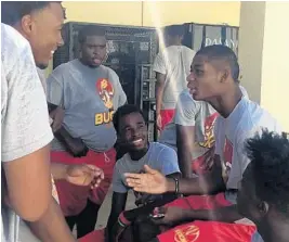  ?? /DAVID FURONES / STAFF PHOTO ?? Deerfield Beach senior cornerback Demetrius Palmer, right, still unable to participat­e in workouts, is surrounded by teammates happy to see him back as he returns to the Bucks.