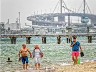  ?? FAIRFAX ?? People seek relief from the hot weather at Port Melbourne beach yesterday as the Westgate Bridge towers in the background.