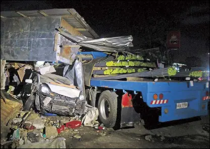  ??  ?? A 14-wheeler truck loaded with steel bars lies against the ruins of a bakery after the truck smashed into 19 vehicles in Sta. Rosa, Laguna Saturday night.