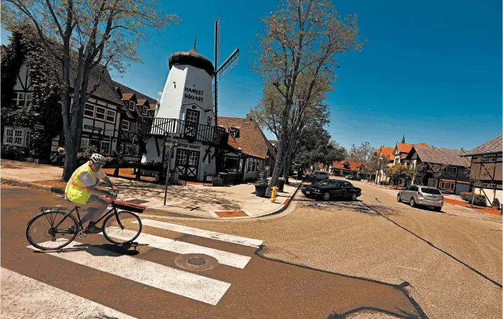  ?? GENARO MOLINA/LOS ANGELES TIMES PHOTOS ?? Chuck Stacy, 72, bikes down a street usually filled with cars and tourists in downtown Solvang, California, in mid-April. Stacy, a retired preacher, has spent 53 of his 72 years in Solvang.