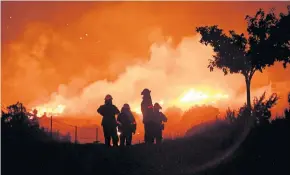  ?? REUTERS ?? Los Angeles County firefighte­rs keep watch on a wildfire as it burns through the night in Juniper Hills, California, in this Sept 19 file photo.
