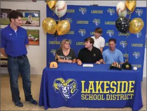  ?? The Sentinel-Record/Mara Kuhn ?? SIGNING DAY: Lakeside baseball coach Leighton Hardin, left, congratula­tes Race Tittle, seated center, before the former Ram player signs with the University of Arkansas at Pine Bluff on Thursday. Also pictured are Tittle’s mother Amanda, sitting left,...