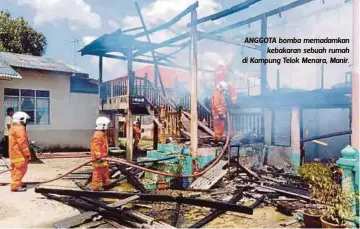  ??  ?? ANGGOTA bomba memadamkan
kebakaran sebuah rumah di Kampung Telok Menara, Manir.