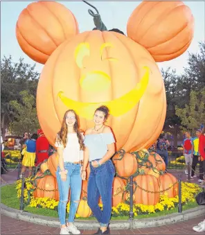  ?? STEVE MACNAULL PHOTO ?? Spanish exchange student Patri Gil Diez (left) and Grace MacNaull pose at the giant Mickey Mouse-shaped jacko-lantern anchoring Main Street U.S.A. at Disneyland.