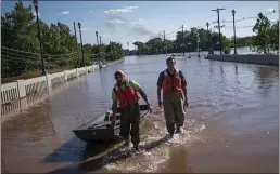  ?? EDUARDO MUNOZ ALVAREZ — THE ASSOCIATED PRESS ?? United States Geological Survey workers push a boat as they look for residents on a street flooded as a result of the remnants of Hurricane Ida in Somerville, NJ., Thursday.