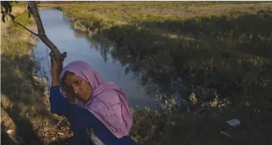  ?? (Susana Vera/Reuters) ?? ROHINGYA REFUGEE Amina Khatun, 55, rests at the bank of the Naf river after crossing it on an improvised raft to reach Bangladesh, on Monday. Two of her sons were killed by gun fire when her village was attacked by Myanmar military, she says.