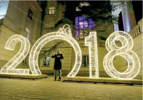  ??  ?? A woman stands next to a festive decoration for the New Year in Sevastopol, Crimea December 29, 2017. REUTERS/Pavel Rebrov