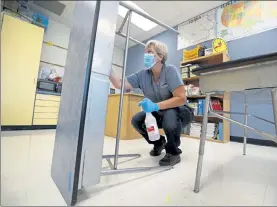  ?? CHARLIE NEIBERGALL / AP ?? Des Moines Public Schools custodian Cynthia Adams cleans a desk in a classroom at Brubaker Elementary School, Wednesday, in Des Moines, Iowa.