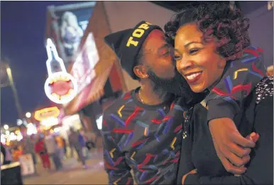  ?? KAREN PULFER FOCHT/THE COMMERCIAL APPEAL ?? Hosea Butler and Tameka Watson of Memphis take in the sights and sounds of Beale Street as darkness falls and the nighttime crowd starts to build.