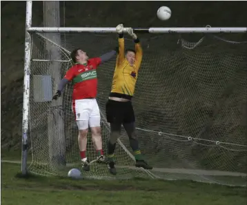  ??  ?? Mark Doyle of Rathnew challenges Hollywood goalkeeper Ian Burke.