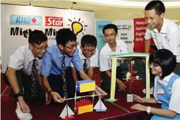  ??  ?? Role models: Mi Xia (right) showing her team’s winning creation to the other champions of the Kedah state challenge.