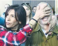  ?? (Reuters) ?? SGT. ELOR AZARIYA is shielded by his mother at the reading of his sentence yesterday in the Jaffa Military Court.