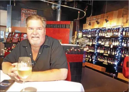  ?? JANET PODOLAK — THE NEWS-HERALD ?? Chef Randal Johnson talks about Molinari’s and what he’s doing to stimulate business. In the background is his wine store, where diners can choose a bottle and pay a $5 corkage fee to drink it with their dinner.