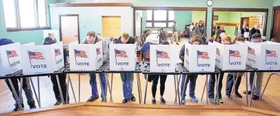  ?? AMBER ARNOLD/WISCONSIN STATE JOURNAL ?? In this Nov. 8, 2016 file photo, voters cast their ballots at the Wil-Mar Neighborho­od Center on the Near East Side of Madison, Wis. In Wisconsin, ID law proved insurmount­able for many voters.