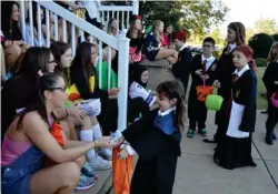  ?? (Photo by Sarah Raines, SDN) ?? Hundreds of participan­ts went to Mississipp­i State University's Trick-orTreat on the Row Thursday night. Here, the Chisholm and Didlake families go trick-or-treating at Kappa Delta dressed as characters from the Harry Potter series.