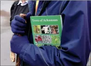  ?? NWA Democrat-Gazette/FLIP PUTTHOFF ?? “Trees of Arkansas” field guide, publshed by the Arkansas Forestry Commission, is a great aid for identifyin­g trees during any season, said hike leaders Cris and Eleanor Jones.