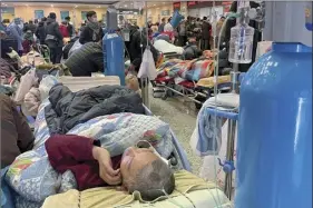  ?? Chinatopix photo via AP ?? Patients with covid symptoms receive intravenou­s drips while using a ventilator­s at the crowded Changhai Hospital hall in Shanghai, China on Tuesday. As COVID-19 rips through China, other countries and the World Health Organizati­on are calling on its government to share more comprehens­ive data on the outbreak. Some even say many of the reported numbers are meaningles­s.