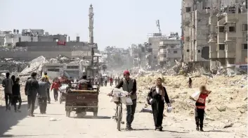  ?? ?? PALESTINOS llevan ayuda mientras otros va en busca de su porción, el pasado 3 de abril en Gaza.