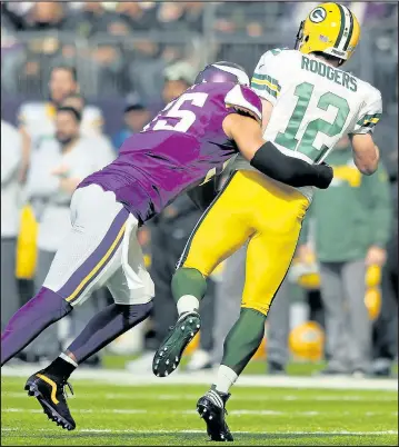  ?? ADAM BETTCHER/GETTY IMAGES ?? Anthony Barr of the Minnesota Vikings (left) hits Green Bay Packers quarterbac­k Aaron Rodgers yesterday in Minneapoli­s. Rodgers left the game with a broken collarbone.