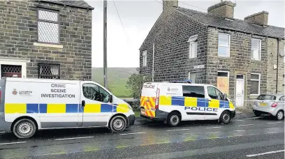  ??  ?? ●● Police at the scene of the suspected arson on Burnley Road in Loveclough.