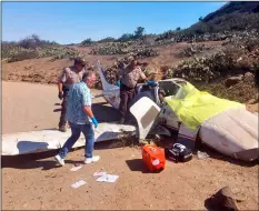  ?? Los ANgeLes CouNTy sherIff’s DePArTmeNT VIA AP ?? This photo provided by the Los Angeles County Sheriff’s department shows first responders examining the scene of a plane crash at the airport near Avalon on Santa Catalina Island off the Southern California coast on Wednesday.