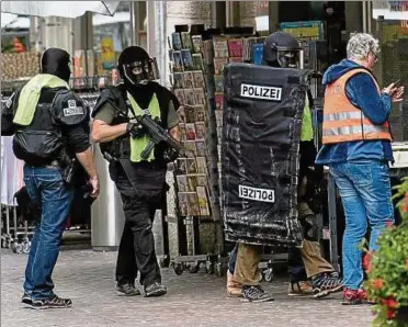  ??  ?? Mit Matten geschützt – so suchen Polizisten in der Innenstadt von Schaffhaus­en nach dem Angreifer. Foto: dpa