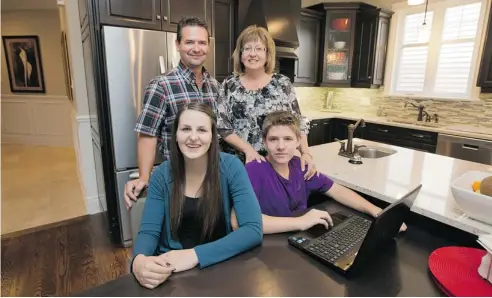  ?? WAYNE CUDDINGTON/OTTAWA CITIZEN ?? Homework is a family affair for Barbara Champagne and her family, husband Don Bergeron and children Nick, 14, and Karlene, 16. Champagne grew up doing homework at the kitchen table, under the watchful eye of her mother.