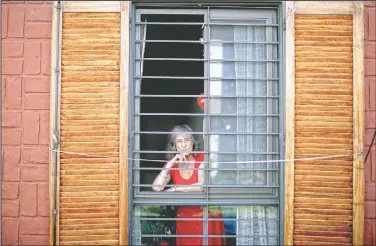  ?? (AP/Natacha Pisarenko) ?? Carmela Corleto looks out of her home where she lives alone in Burzaco, Argentina. Corleto said she has carried out strict isolation to avoid getting covid-19 and sees it more as a goal than a burden.