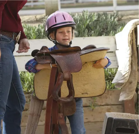  ??  ?? I can do it! Kids learn responsibi­lity caring for a horse, and the activities involved—including hefting saddles—build muscles and boost balance, coordinati­on, and flexibilit­y. Horseback riding itself offers proven aerobic-exercise benefits, getting...