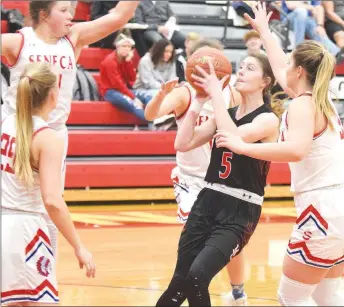  ?? RICK PECK/SPECIAL TO MCDONALD COUNTY PRESS ?? McDonald County’s Sydney Killion finds room to get off a shot despite being surrounded by four Seneca Lady Indians. Killion’s three-pointer with under a minute left keyed the Lady Mustangs’ 42-41 win on Jan. 17 at Seneca High School.