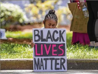  ?? ALYSSA POINTER / ALYSSA.POINTER@AJC.COM ?? Corri Griffith, 5, rests Monday as she and her father, Corey Griffith, who was close by, listen to protesters speak at a rally near the steps of Atlanta City Hall.