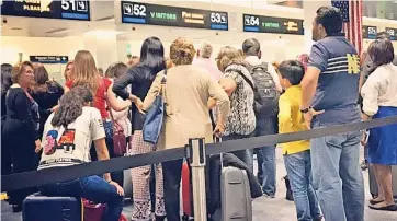  ??  ?? Un grUpo de personas esperan en la sección de control de pasaportes en el aeropuerto de Miami, en enero pasado