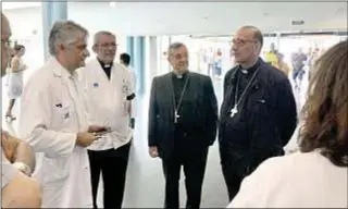  ?? Arzobispad­o de Barcelona ?? El cardenal Juan José Omella, junto a Sebastià Taltavull, saluda a los responsabl­es médicos del Hospital del Mar en su visita a los heridos