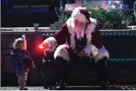  ??  ?? Santa does a magic trick for 16-month-old Iona McKnight during a visit to Winter Wonderland at Children’s Wonderland Park on Tuesday in Vallejo.