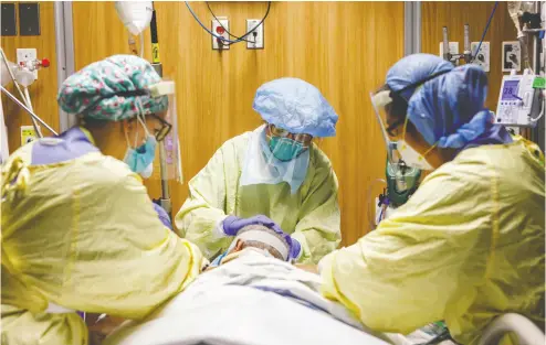  ?? COLE BURSTON / AFP VIA GETTY IMAGES FILES ?? Health-care workers tend to a patient suffering from COVID-19 at Humber River Hospital in Toronto in April.