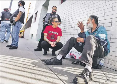  ?? Brian van der Brug
Los Angeles Times ?? NAOMI KUHLMAN, who volunteers with a nonprofit aimed at ending veteran homelessne­ss, talks with a homeless man on downtown L.A.’s skid row in December. Recent figures show the city has seen a 6% increase in the homeless veteran population since 2013.