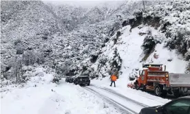  ?? Photograph: CALTRANS/Reuters ?? Cars stranded due to snowfall on the Angeles Crest highway are assisted by a Caltrans crew in California on 28 November.