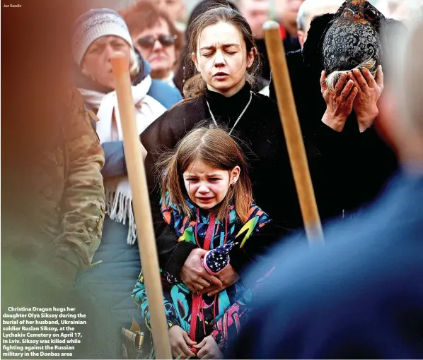  ?? Joe Raedle ?? > Christina Dragun hugs her daughter Olya Siksoy during the burial of her husband, Ukrainian soldier Ruslan Siksoy, at the Lychakiv Cemetery on April 17, in Lviv. Siksoy was killed while fighting against the Russian military in the Donbas area