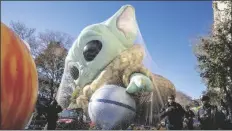  ?? TED SHAFFREY/AP ?? POLICE WALK BY AN INFLATED HELIUM BALLOON of Grogu, also known as Baby Yoda, from the Star Wars show The Mandaloria­n, Wednesday, in New York, as the balloon is readied for the Macy’s Thanksgivi­ng Day Parade on Thursday.