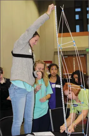  ?? Janice McIntyre/News-Times ?? Mentoring to extreme heights: Carolyn Smith, right, science chair for the El Dorado School District, measures a ‘World Tower,’ created by El Dorado High School students and mentors, during a Million Women Mentors event at South Arkansas Community...