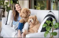  ?? Courtesy of Jennifer Adams ?? Happy at home: Designer and author Jennifer Adams relaxes in her San Diego home with her labradoodl­es, Jaxx and Theo.