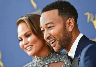  ?? AFP / Getty Images ?? Chrissy Teigen in Zuhair Murad celebrated with husband John Legend, one of the few artists to win Emmy, Grammy, Oscar and Tony awards.